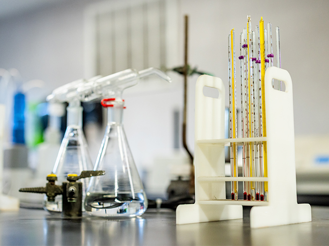 Laboratory bench with Erlenmeyer flasks and a rack of precision thermometers, representing U.S. Sugar's custom specialty cane sweetener formulation and quality testing process