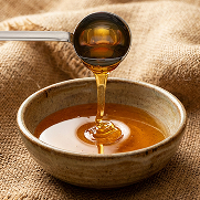 Golden liquid sugar being poured into a bowl, showcasing U.S. Sugar’s refined sweetener products.